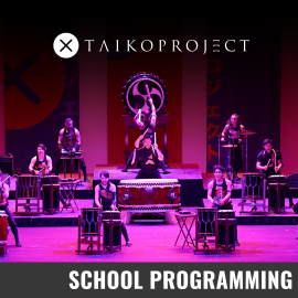 Promotional graphic for TaikoProject. Image shows: Performers are arranged across multiple levels of a brightly lit stage, each playing traditional Japanese drums of various sizes. The overall lighting is vivid, with strong pink and purple tones highlighting the performers and instruments. Event labeled as School Programming.